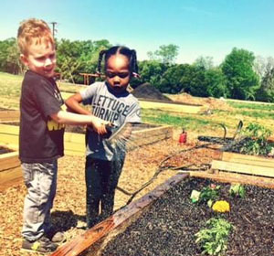Children planting seeds at Eastfield Harvester Community Garden.