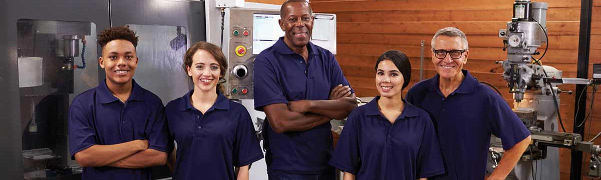Portrait Of Engineers And Apprentices With CNC Machine