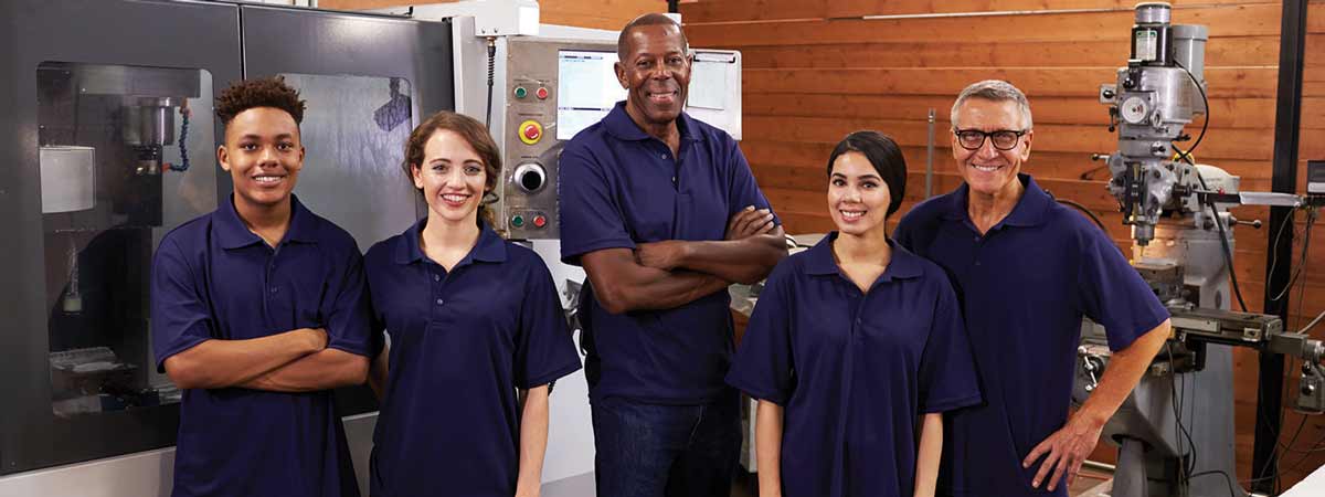 Portrait Of Engineers And Apprentices With CNC Machine