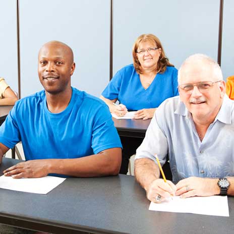 Adult students take notes in their class.