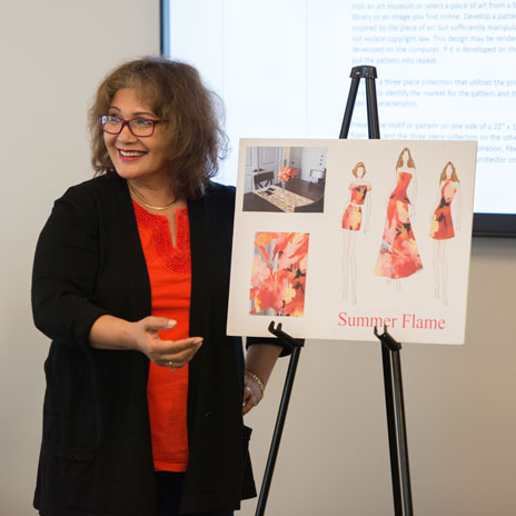 A student shows off their fashion designs.