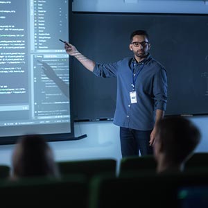 A professor shows on-screen code in front of college class