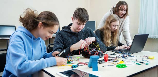 Group of teens building a robot vehicle.