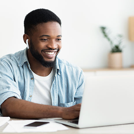 Student using a laptop and smiling