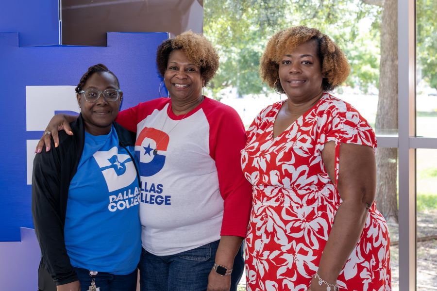 Employees wearing Dallas College tshirts pose for a photo