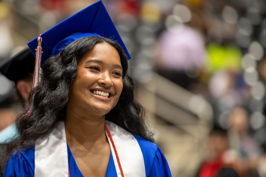 A student gives a big smile at graduation
