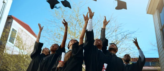 Graduates through their caps into the air