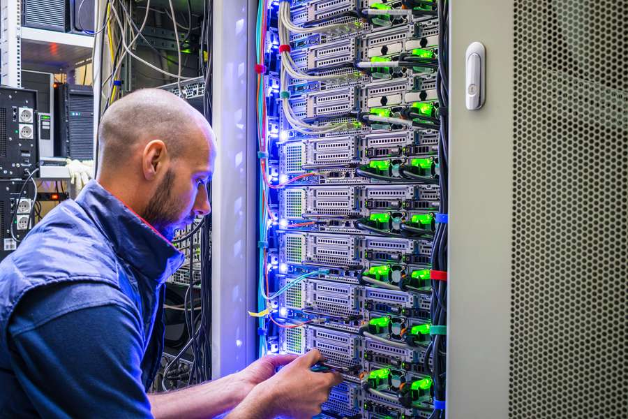 male worker looking inside a computer server