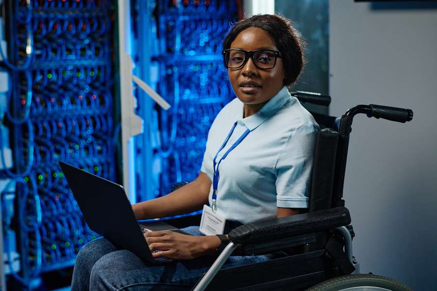 female worker in a wheelchair holding a laptop