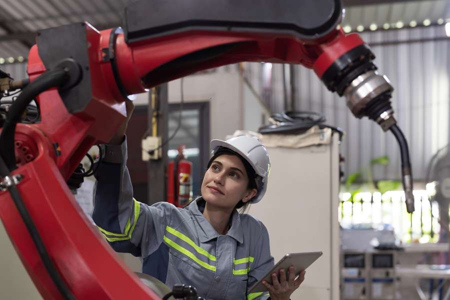 female in uniform working with a large robotic machine