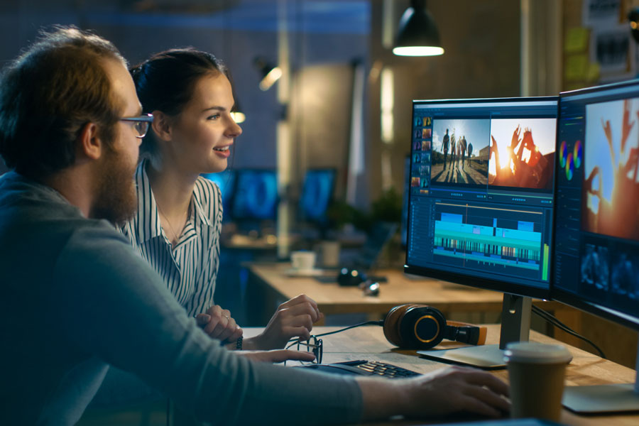 male and female coworkers working together in a studio on a computer