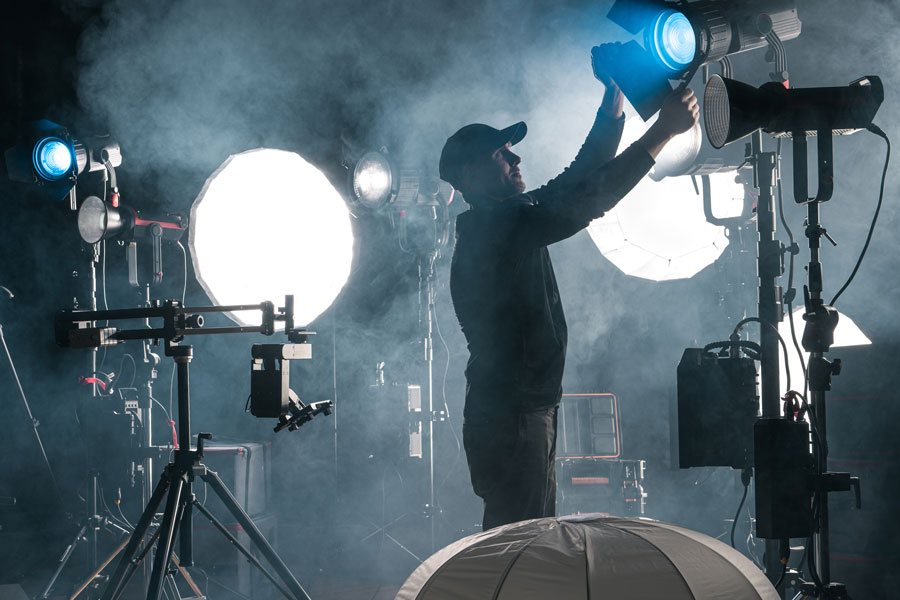man working behind a stage with large production lights