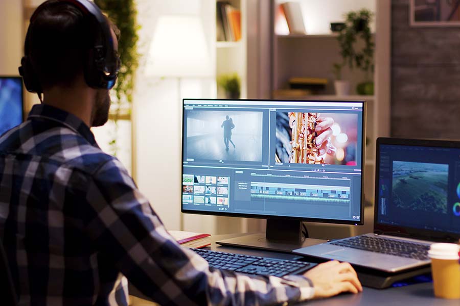 female video editor working with footage and sound with her back to the camera