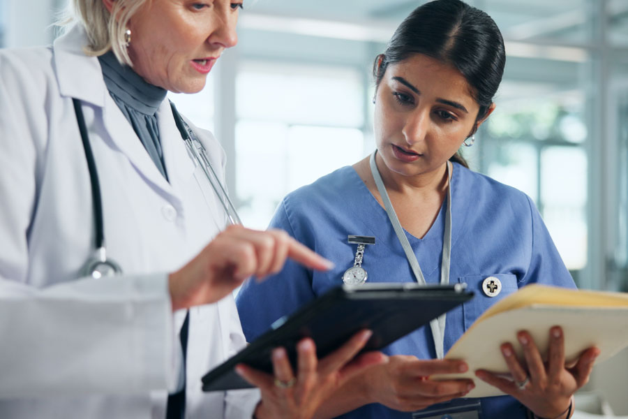 Doctor pointing at tablet and talking to a nurse