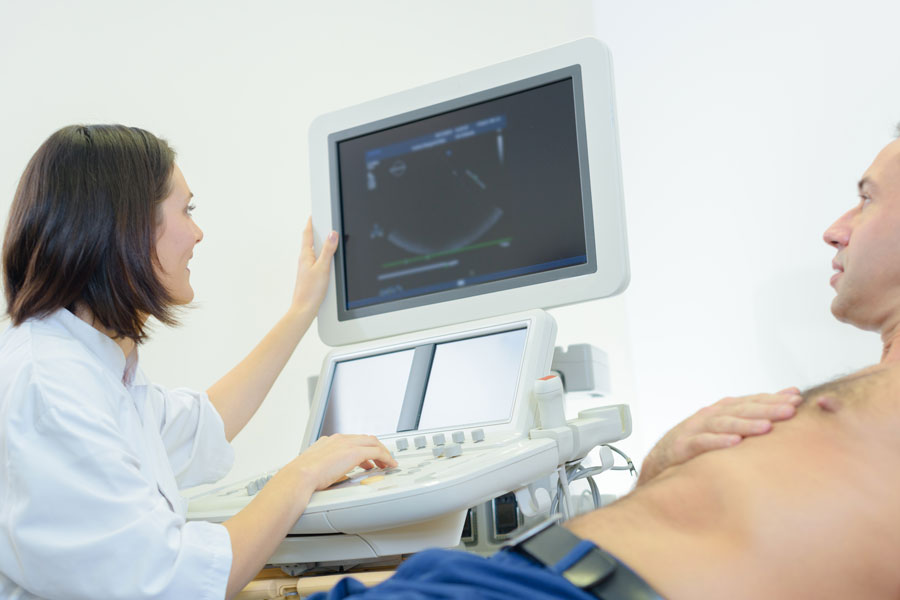 tech looking at monitor with patient explaining procedure