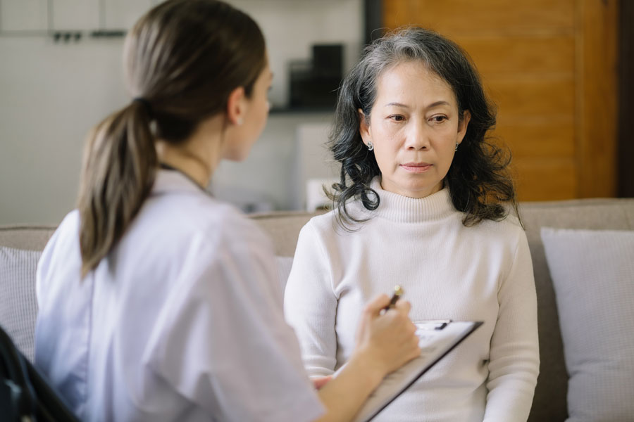 Stressed female senior patient speaking to a psychiatrist in a clinic.