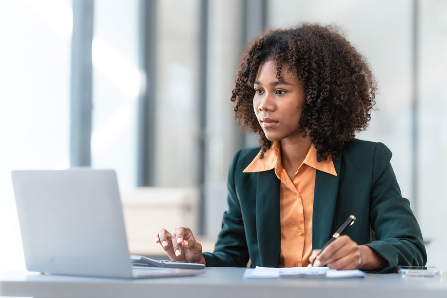 Professional female worker sitting at a desk with laptop.