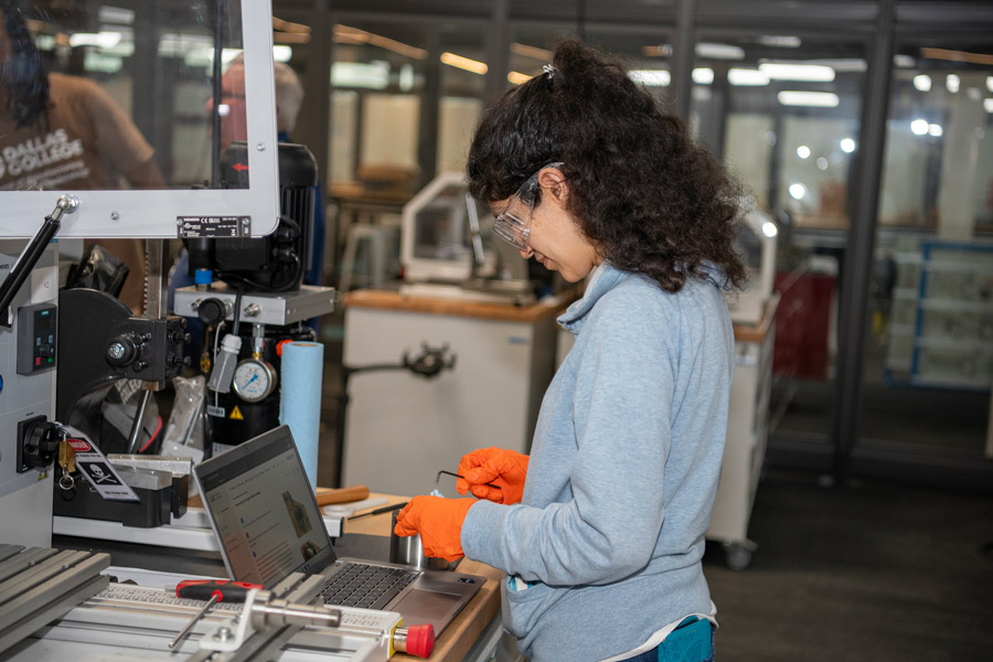 Student working with manufacturing equipment in the Workforce Center at RedBird.