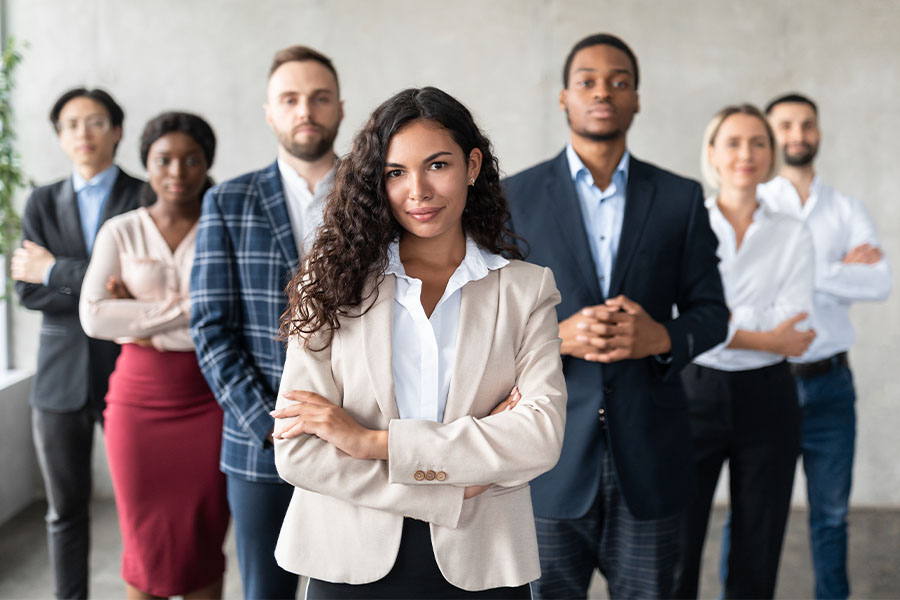 Diverse group of business professionals face camera with folded arms