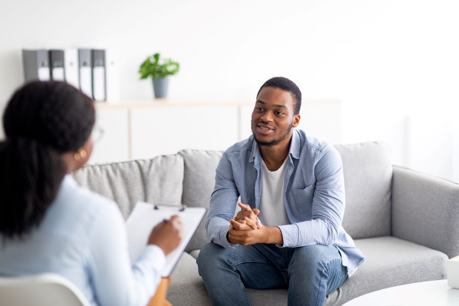 Two people have a discussion while sitting on a couch
