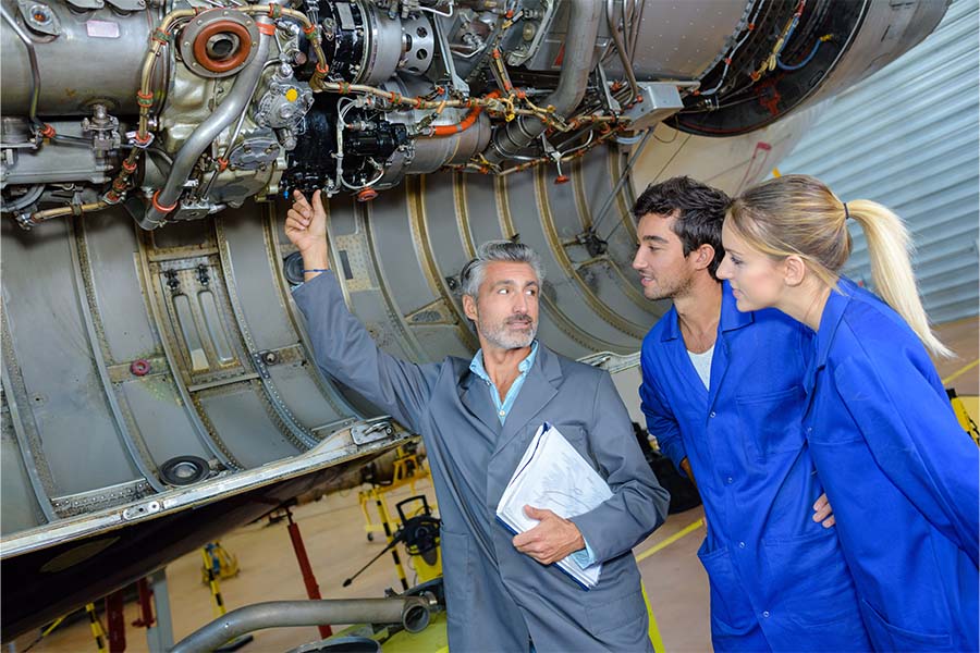 Aviation students receiving instruction on an airplane engine