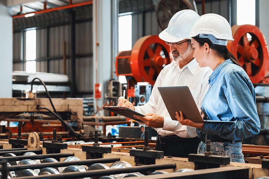 Engineers in a factory reviewing clipboards