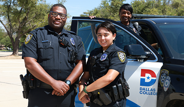 Two police officers posing in front of a police truck