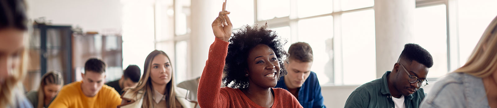 Student raising her hand in a classroom