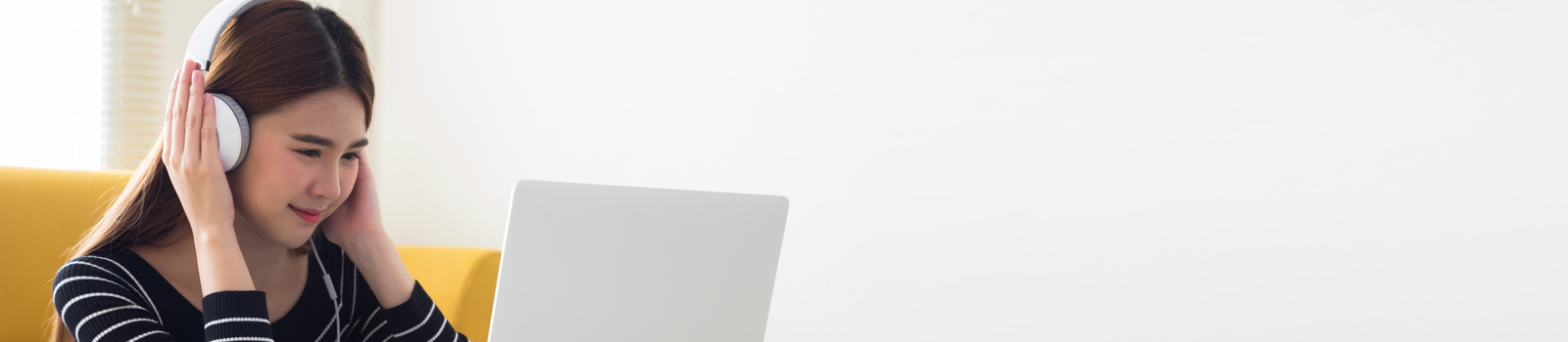 Student on a laptop using headphones