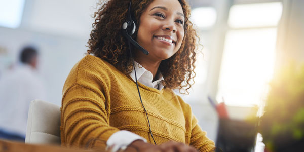 Person wearing a headset while working at a desk.