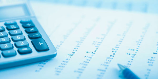 Calculator and financial documents with printed numbers on a desk.
