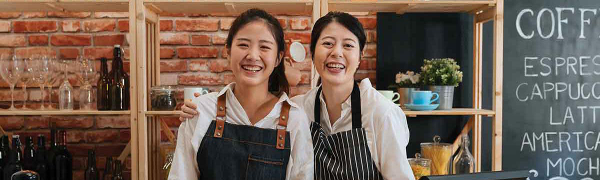 two coffeehouse waitresses smiling