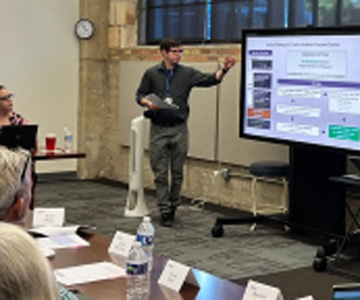 A facilitator points to a board while compression planning participants look on
