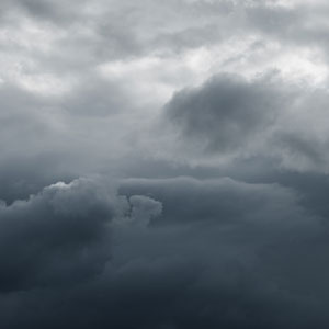 Dark, dense storm clouds fill the sky, exuding a moody and foreboding atmosphere, suggesting an impending storm
