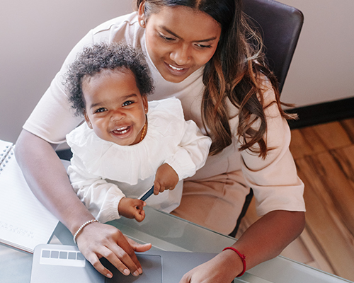 A mother student taking classes online with Dallas College to care for her baby at home