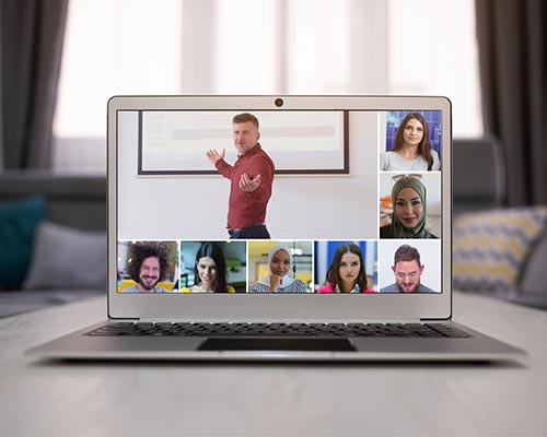 A laptop showing a video call with college professor and students for online classes