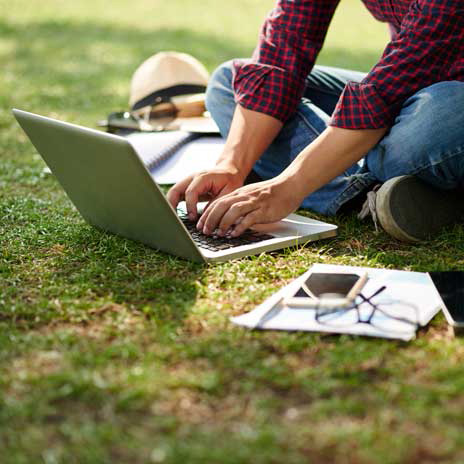 Student types on a laptop outdoors