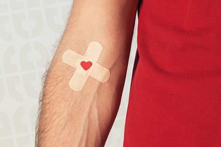 Closeup of an arm with two band aids on the elbow