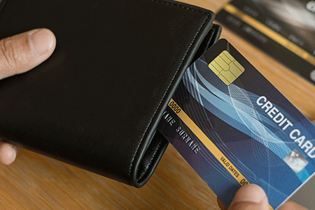close-up of a person taking a credit card out of a wallet