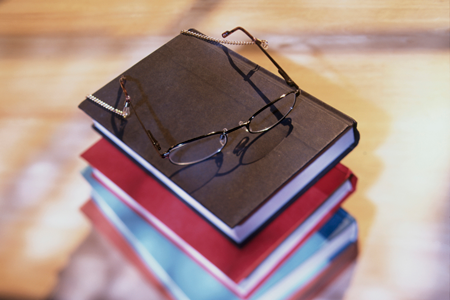 a stack of books with a pair of glasses on top