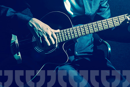 close-up of a hand playing a guitar