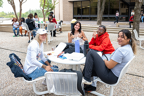group of female students sitting outside together
