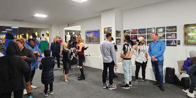 Visitors look at artwork at the opening of a recent art show in the art gallery