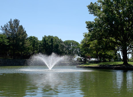 A fountain is flowing in the middle of the lake at Richland Campus
