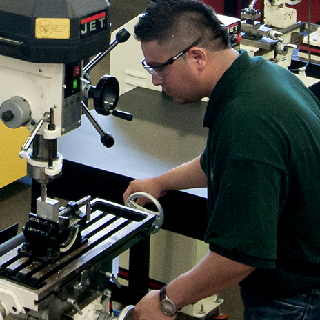 A student works on a drill press at the Garland Center
