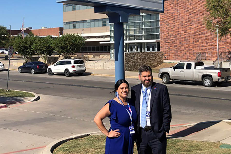 Dr. Justin Lonon standing in front of W.H. Adamson High School with Principal Stephanie Amaya.