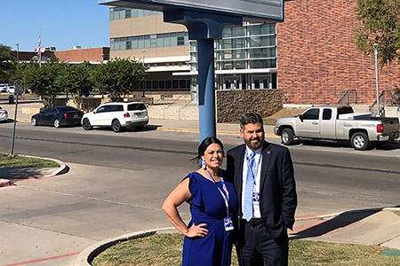 Dr. Justin Lonon standing in front of W.H. Adamson High School with Principal Stephanie Amaya.
