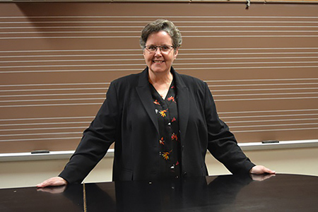 Kathryn Brownlee standing behind a piano.