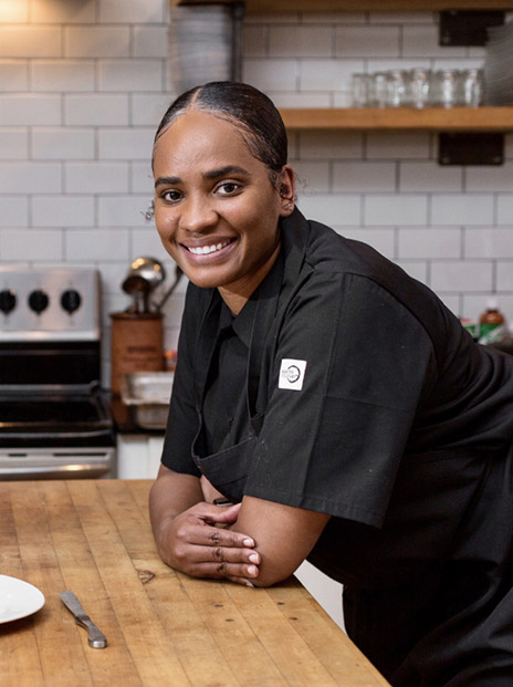Temika McCaskill leaning on kitchen counter.