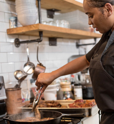 Temika McCaskill tending meat in a frying pan.